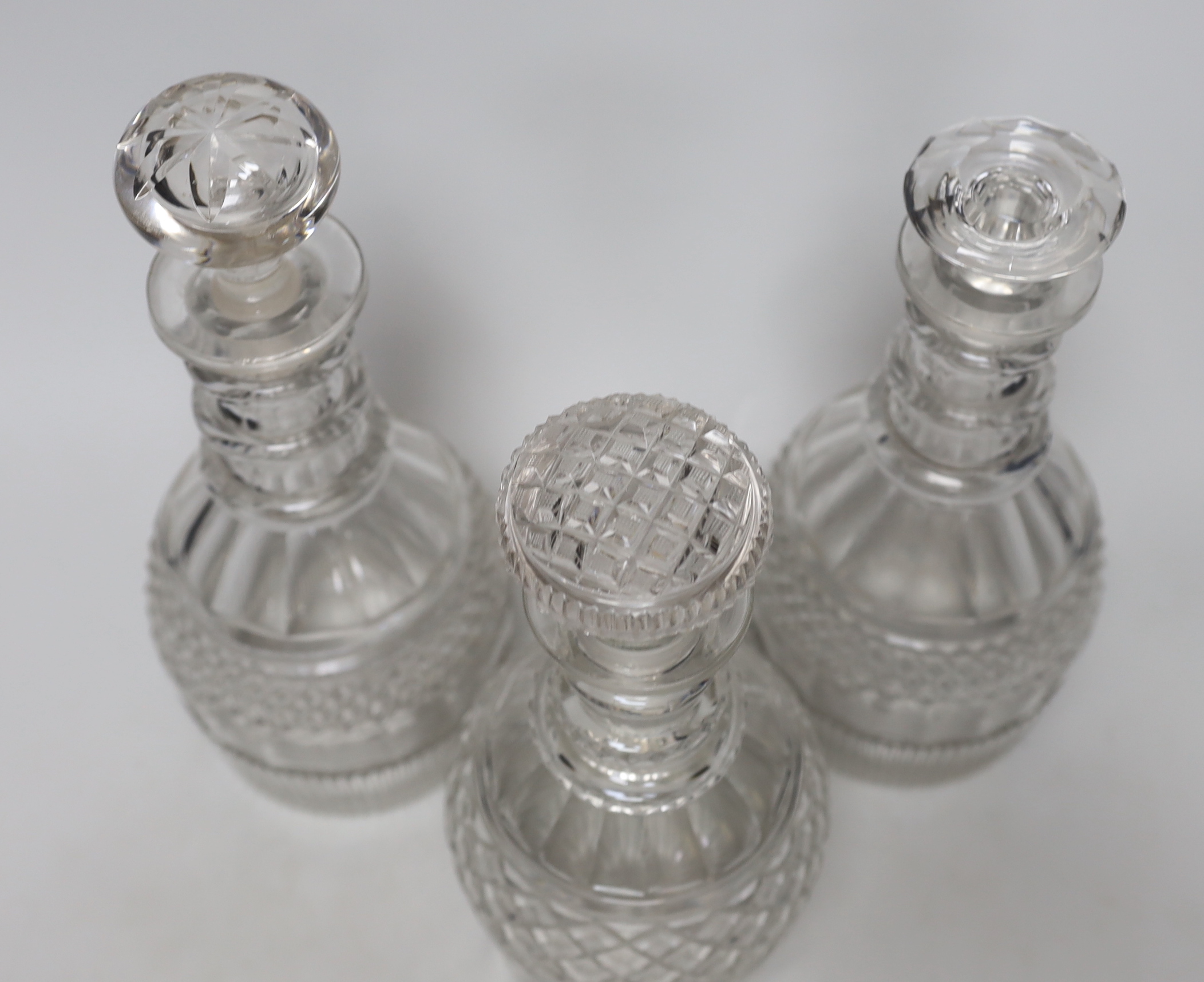 Three William IV cut glass decanters, all in a similar design with three neck rings and two with flattened stoppers, highest 28cm (3)